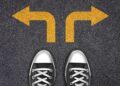 Pés apontados para dois caminhos com setas amarelas indicando direções opostas.
