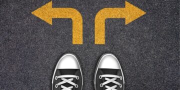 Pés apontados para dois caminhos com setas amarelas indicando direções opostas.